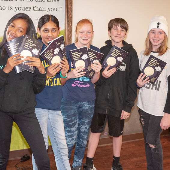 Student authors holding copies of their book