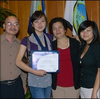 Student holding certificate, posing with family