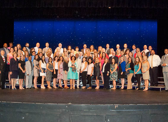 Large group of program graduates posing in stage