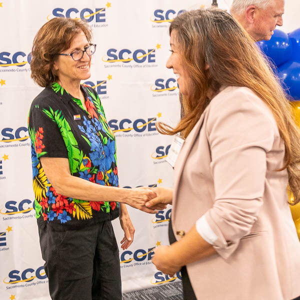 Board trustee shaking hands with graduate