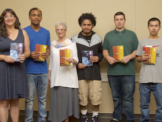 Students holding books pose with authors