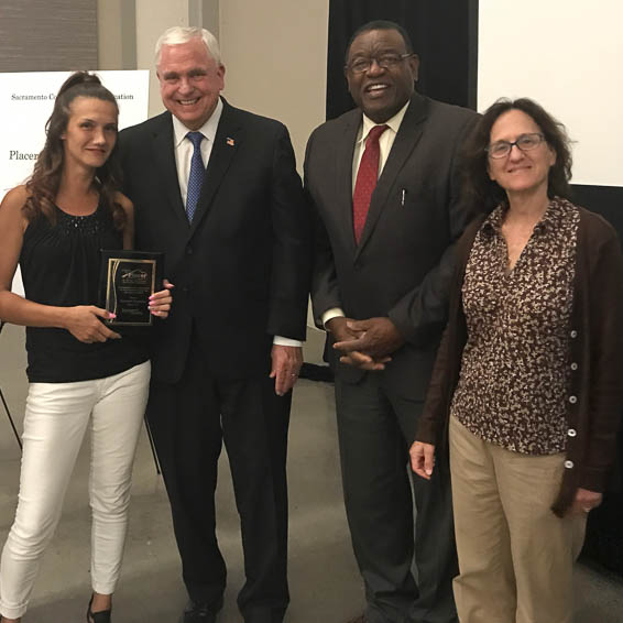 Dave Gordon, Alfred Brown, and Bina Lefkovitz with client holding award