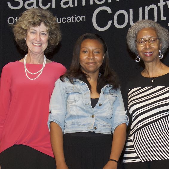 Student posing with Board members