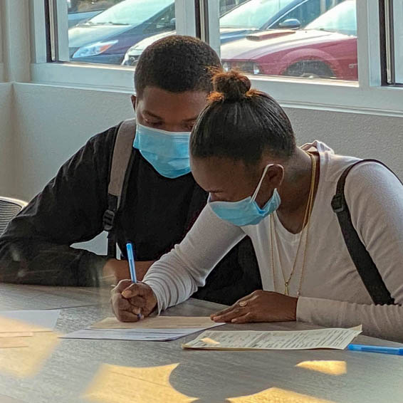 Students filling out paperwork at a table