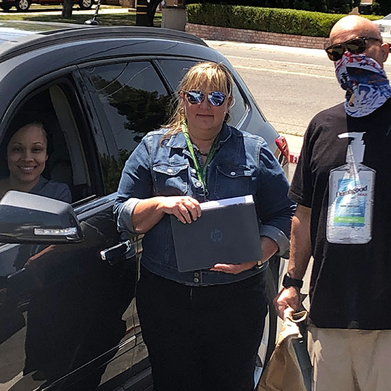 Lauren Roth and Sterling Alley standing next to parent's car, handing out ingredients