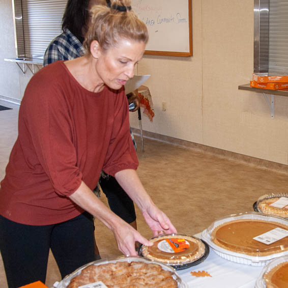 Teacher arranging pies on table