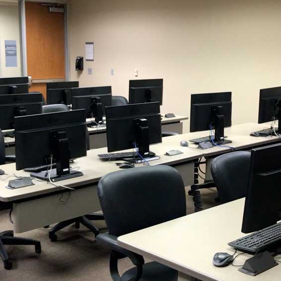 Empty computer lab with computer monitors on tables