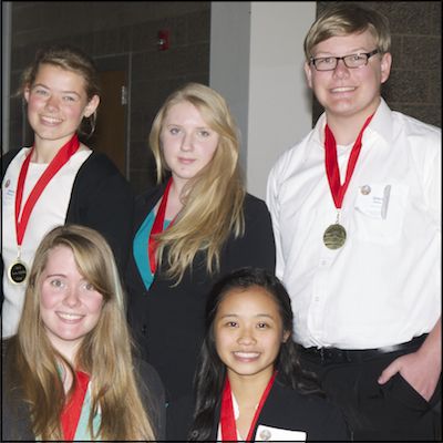 Five students wearing medals