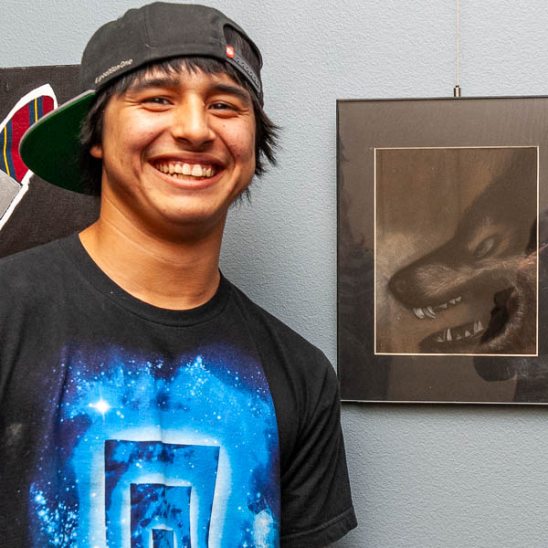 Student posing with artwork