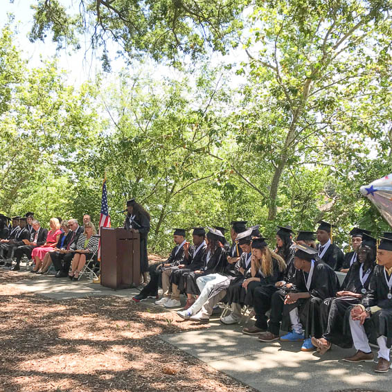 Graduated seated in a row next to podium