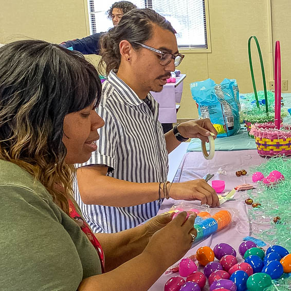 Students talking as they fill baskets with eggs