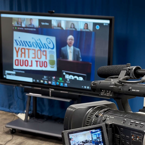 Camera in front of television showing video conference ceremony