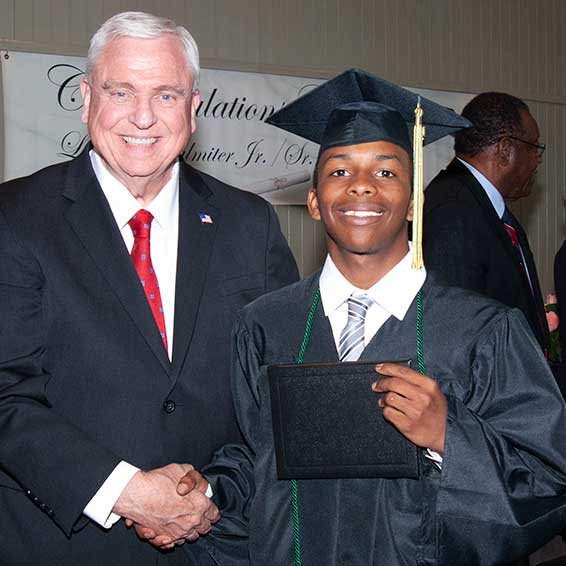 Superintendent shaking hands with graduate