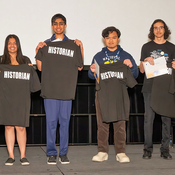 Students posing, holding with historian shirts