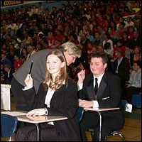 Decathletes competing in the Super Quiz with crowd behind