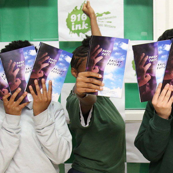 Students holding up copies of books