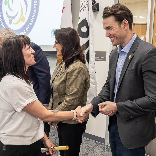 Graduate shaking hands with Congressman Kiley