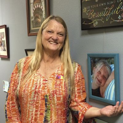 Employee proudly standing next to her artwork