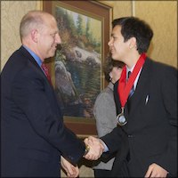 Judge Lawrence Brown shaking hands with a student