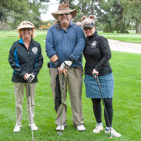 Group of three golfers leaning on golf clubs