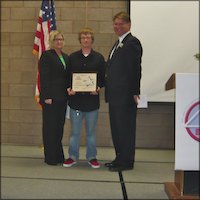 Rodney Hilton on stage holding certificate