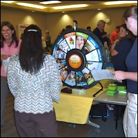 Employees spinning a prize wheel at health fair
