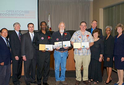 Board members standing with diploma recipients