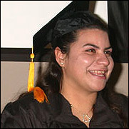 Graduate in cap and gown, smiling