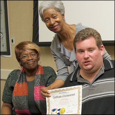 Board trustee presenting certificate of achievement to student