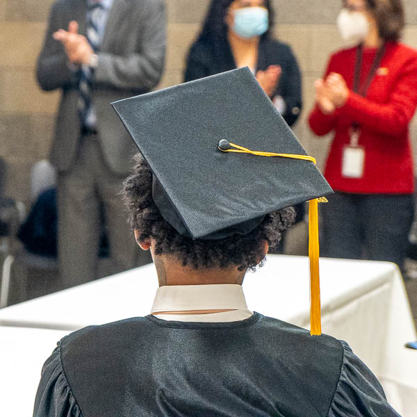 Audience applauding seated graduate