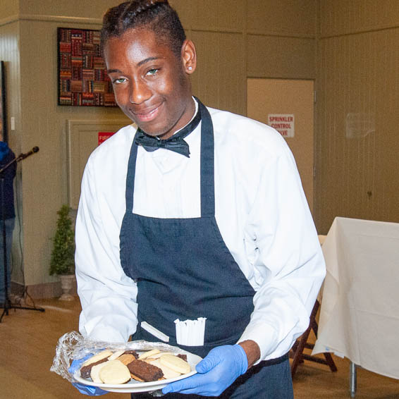 Student server holding plate of cookies