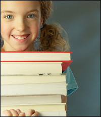 Smiling girl holding a stack of books