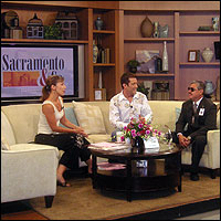 Frank Lopez sitting on sofa with Kristen Simoes and Guy Farris